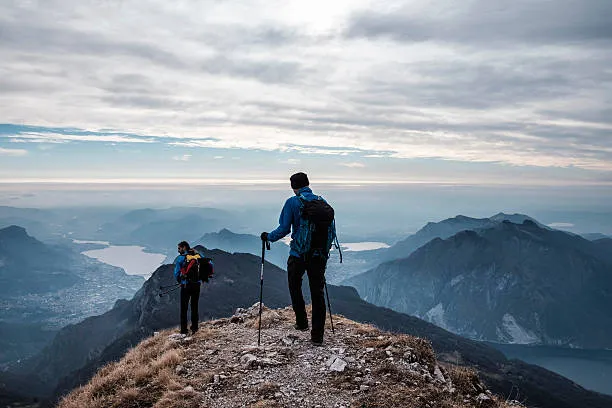 The slow grind of reasonable compromise 1 man hiking ontop of mountain - Newcastle Branding Agency